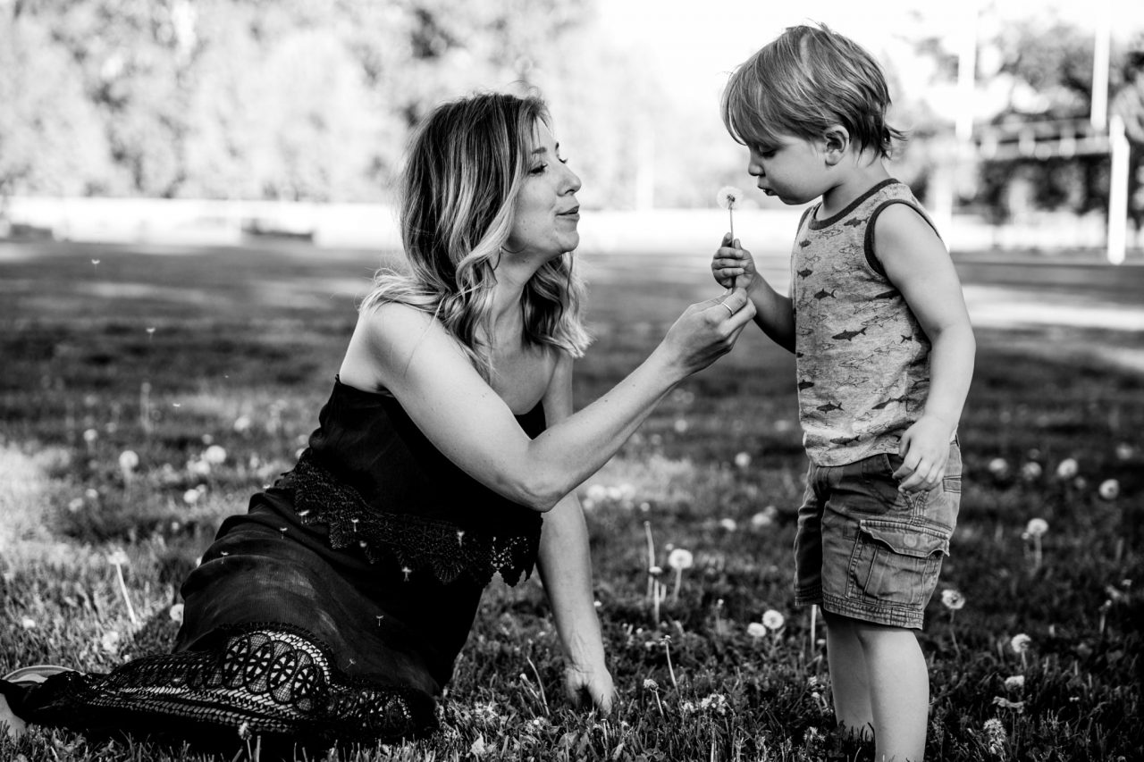 mother and son blowing dandelions at city park kelowna